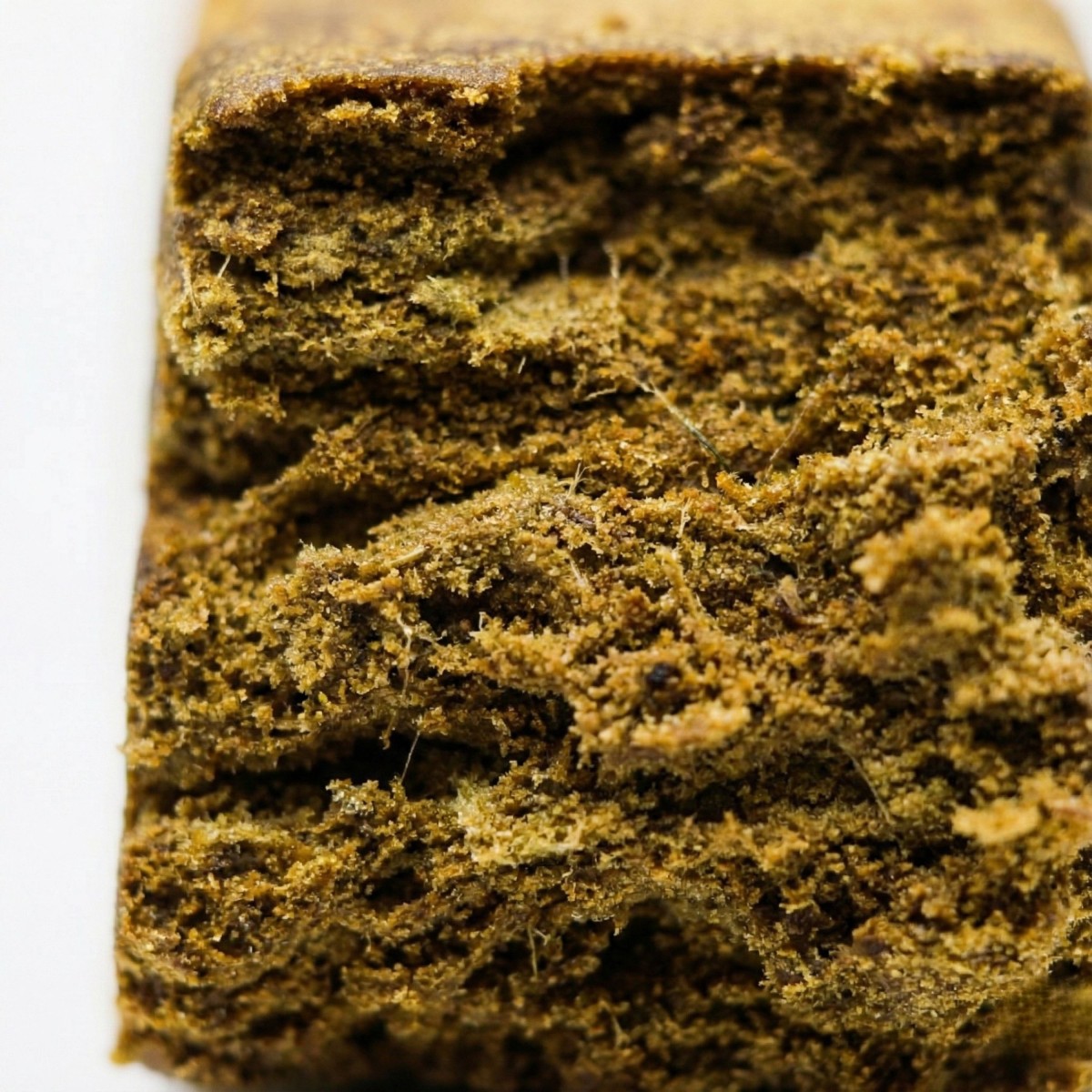 Gros plan sur la texture sableuse du Dry Hash CBD bio. Une résine de chanvre pure et concentrée
