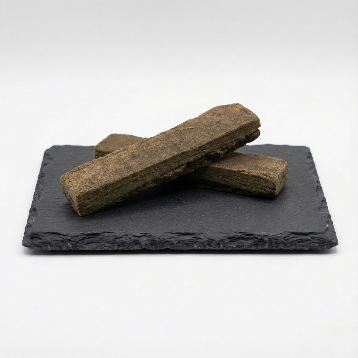 Résine BBM Hash CBD bio sur présentoir en ardoise. Un hashish de chanvre à la texture pressée