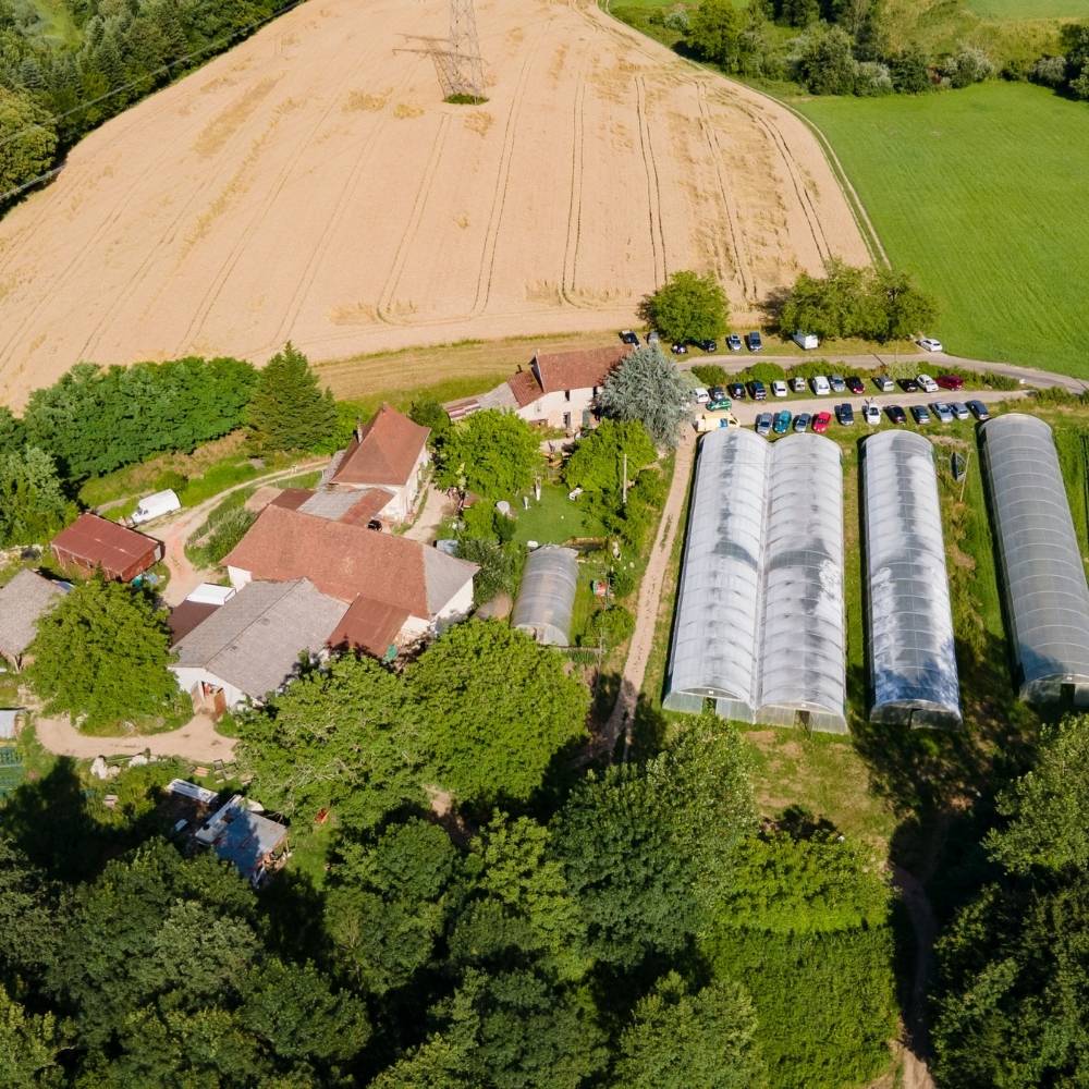 Vue aerienne d une ferme bio avec serres agricoles et champs cultives.