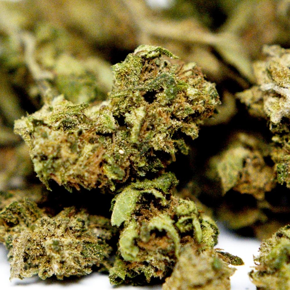 Zoom sur fleur CBD Cannatonic avec details des cristaux et feuilles proches du bourgeon.