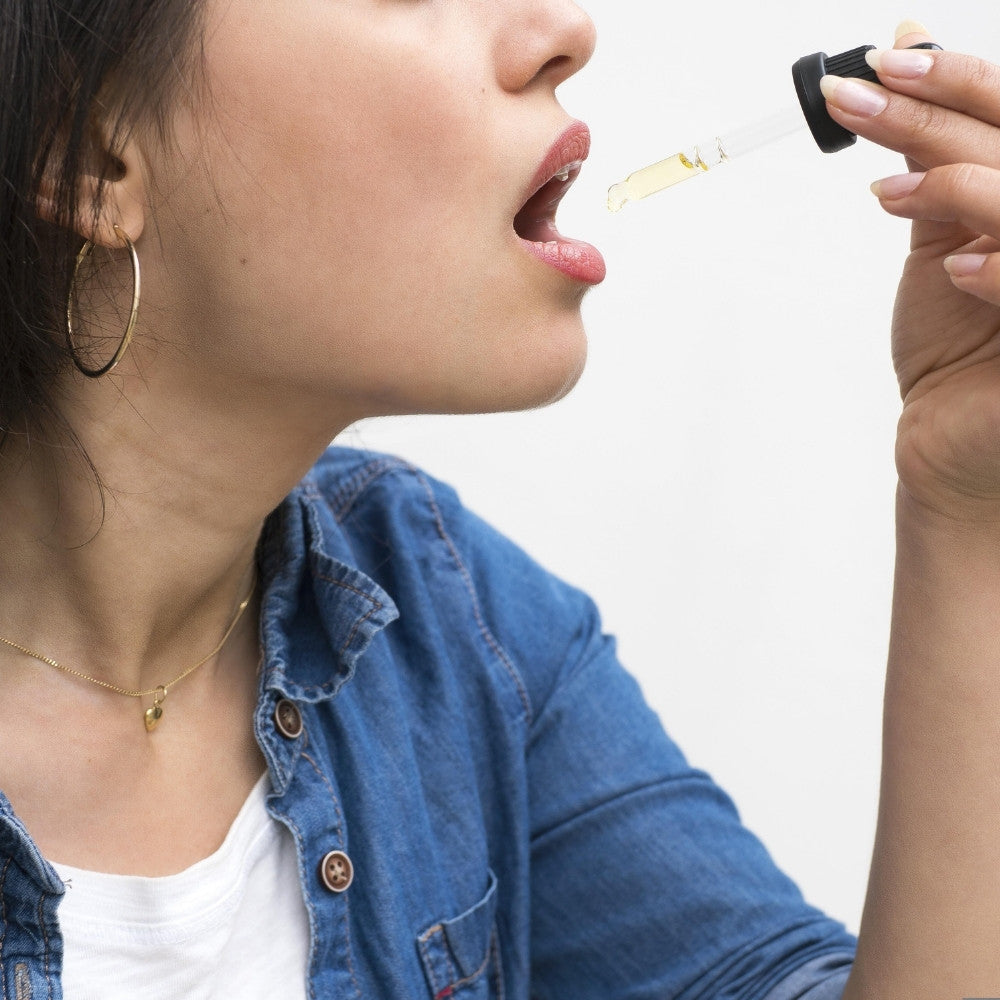 Prise sublinguale d huile CBD avec pipette pour un dosage precis et une ingestion directe