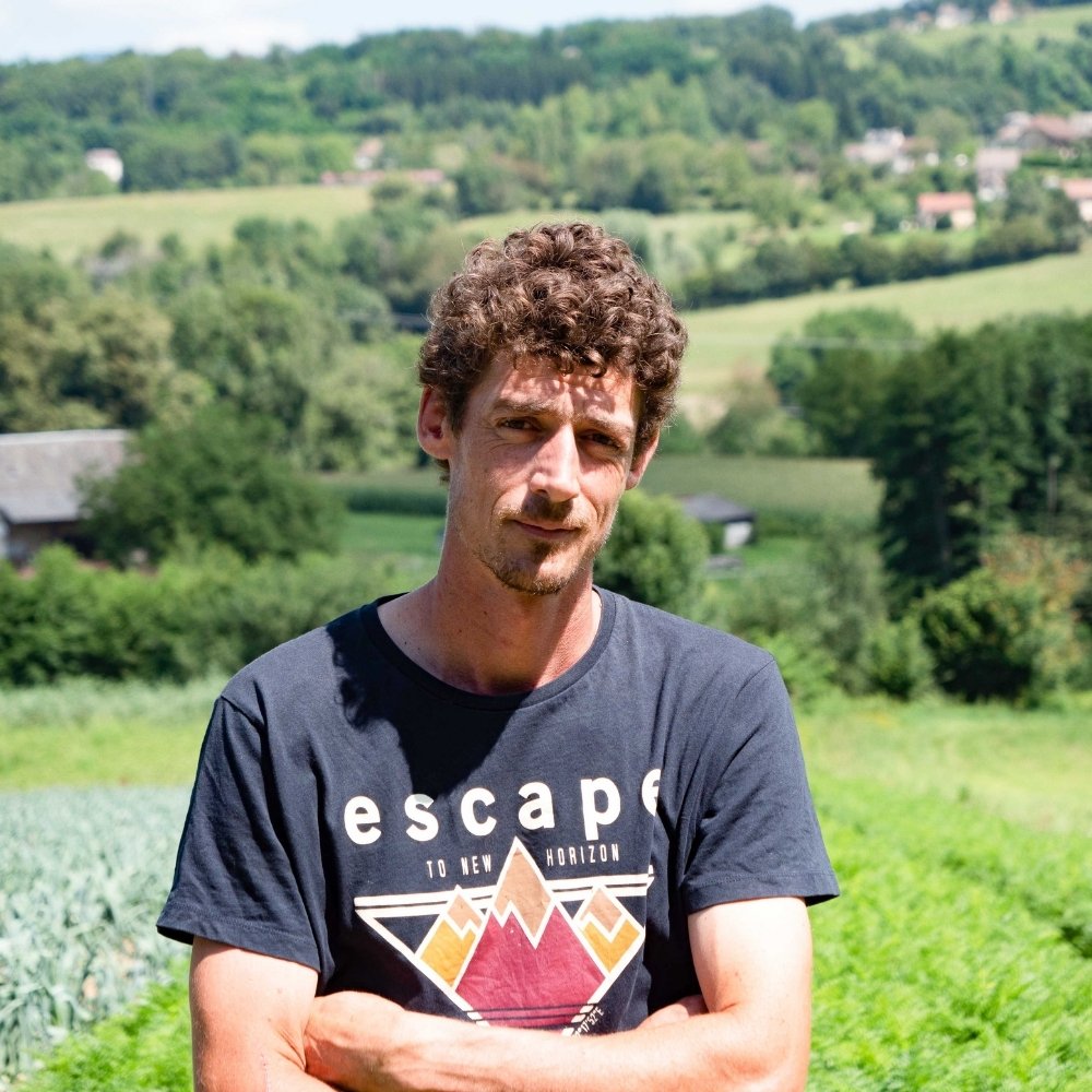 Portrait d'un membre de l'équipe Trikome devant les champs de culture, témoignant de l'engagement humain derrière la production de CBD bio français.