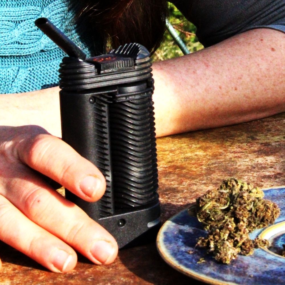 Vaporisateur d’herbes sèches avec fleur CBD au format carré, illustration d’une consommation sans combustion en extérieur.